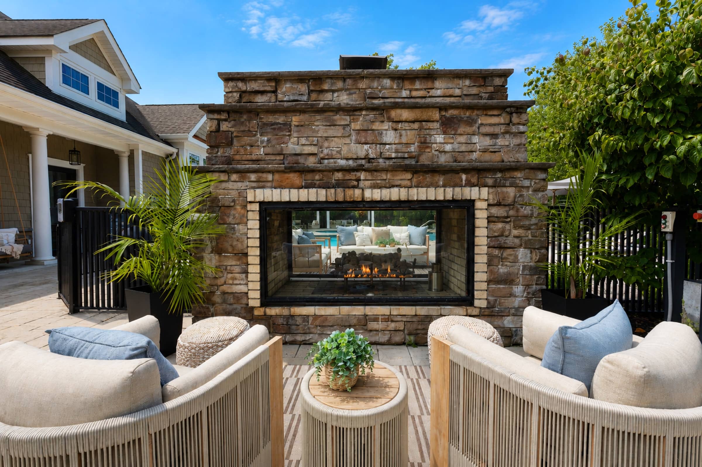 Outdoor stone fireplace with curved lounge seating